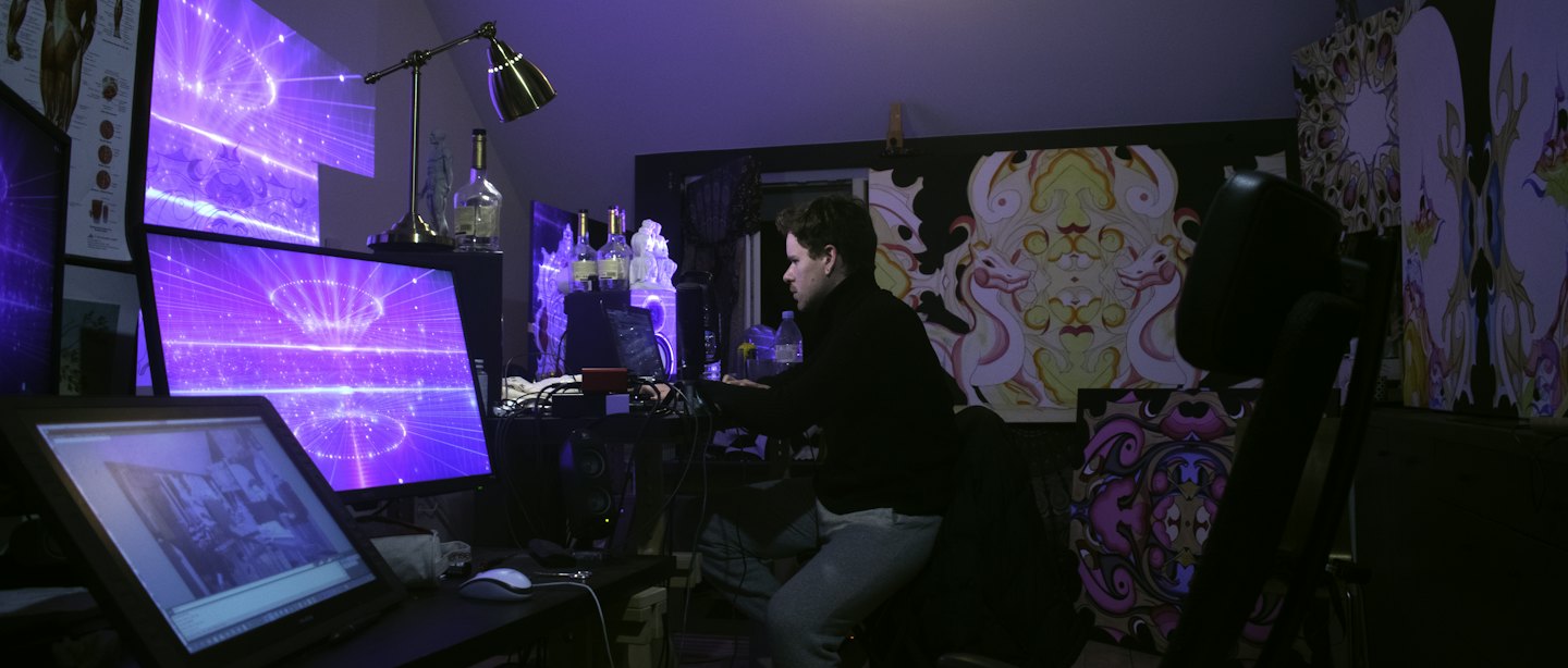 Graphic designer working at a multi-monitor computer station.