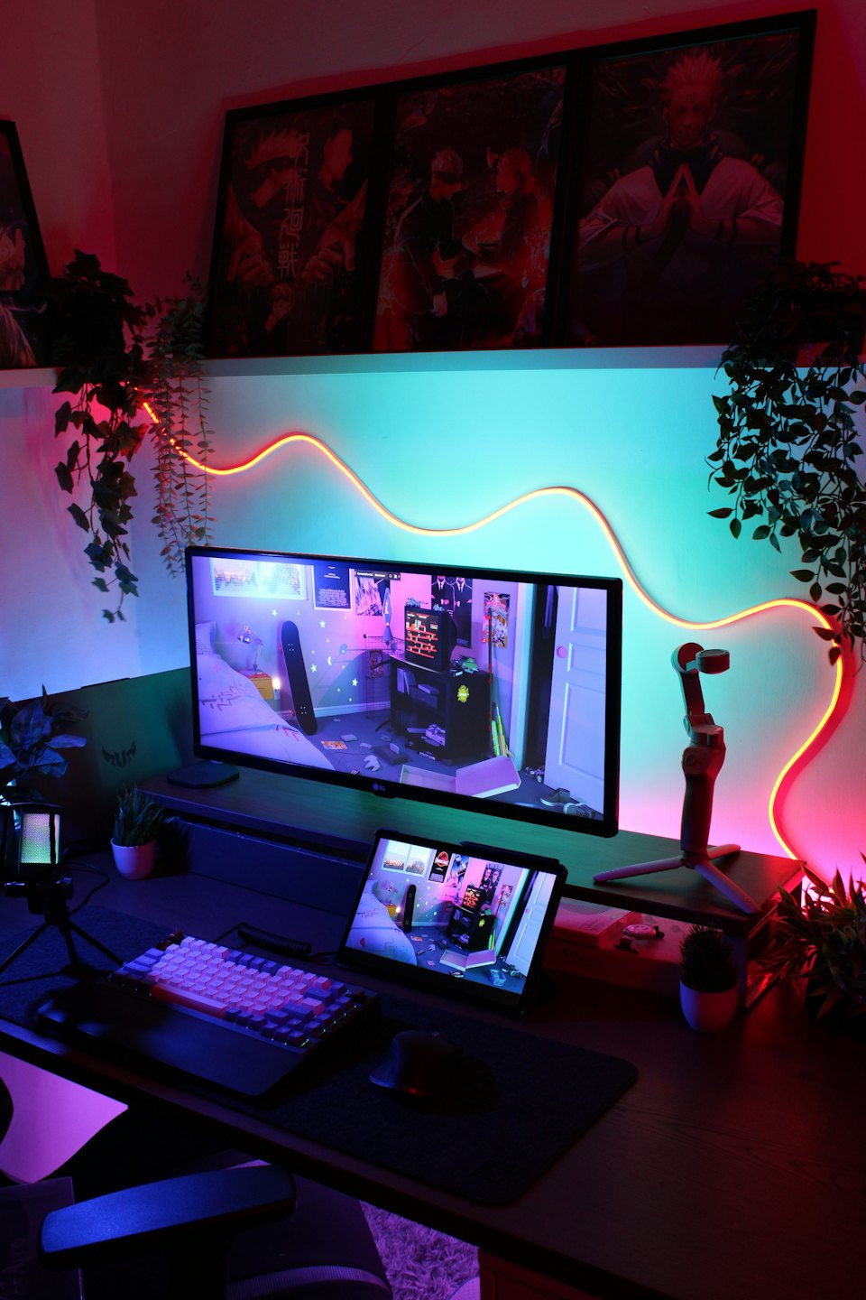 RGB lit gaming desk with computer, tablet, keyboard, and microphone.